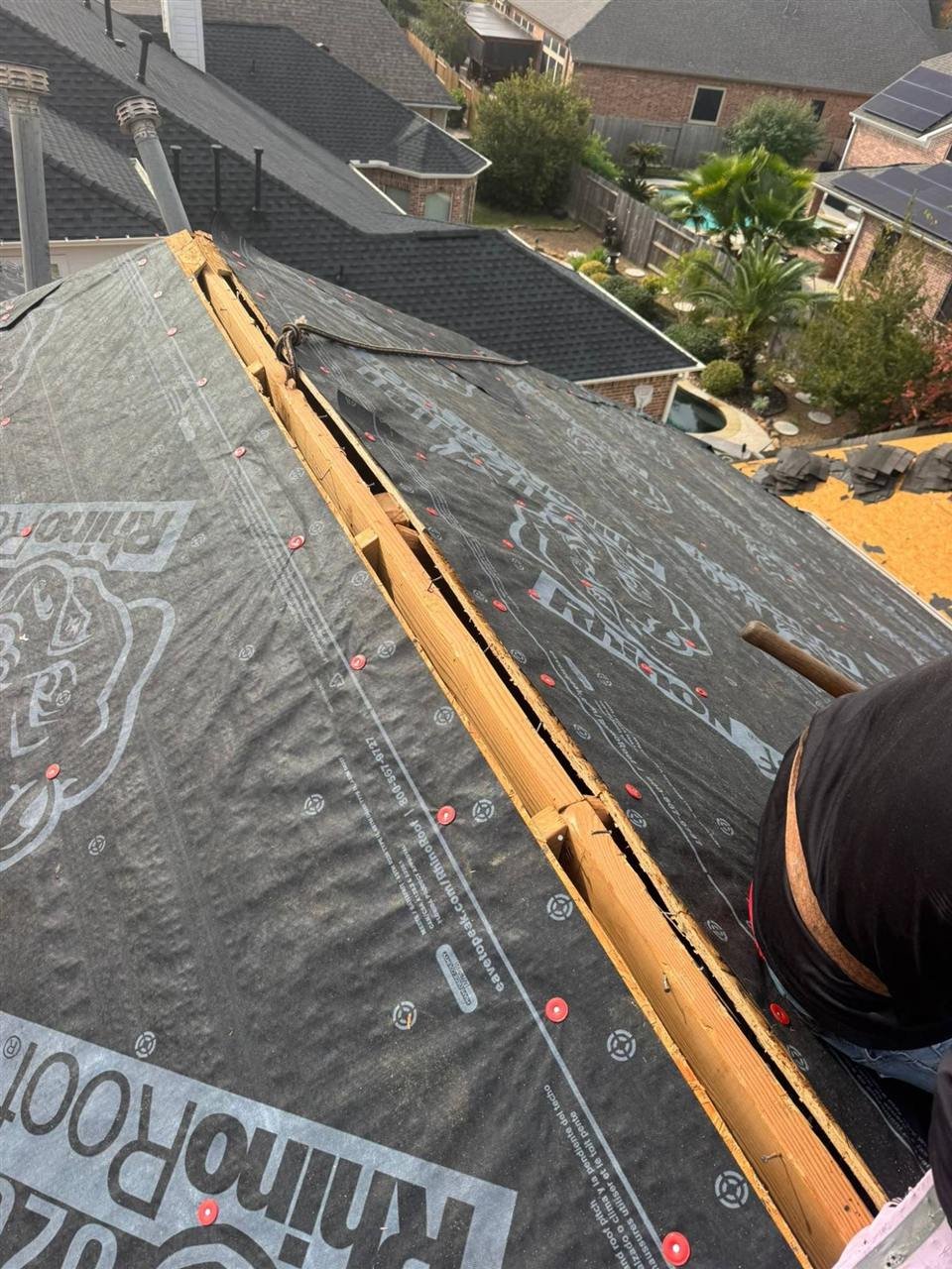 Synthetic underlayment with cap nails along the ridge of a roof replacement in Houston, TX